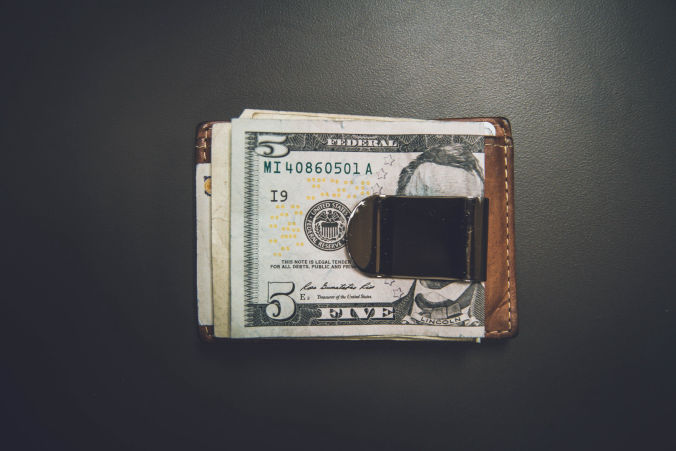Money clip with money on dark background.